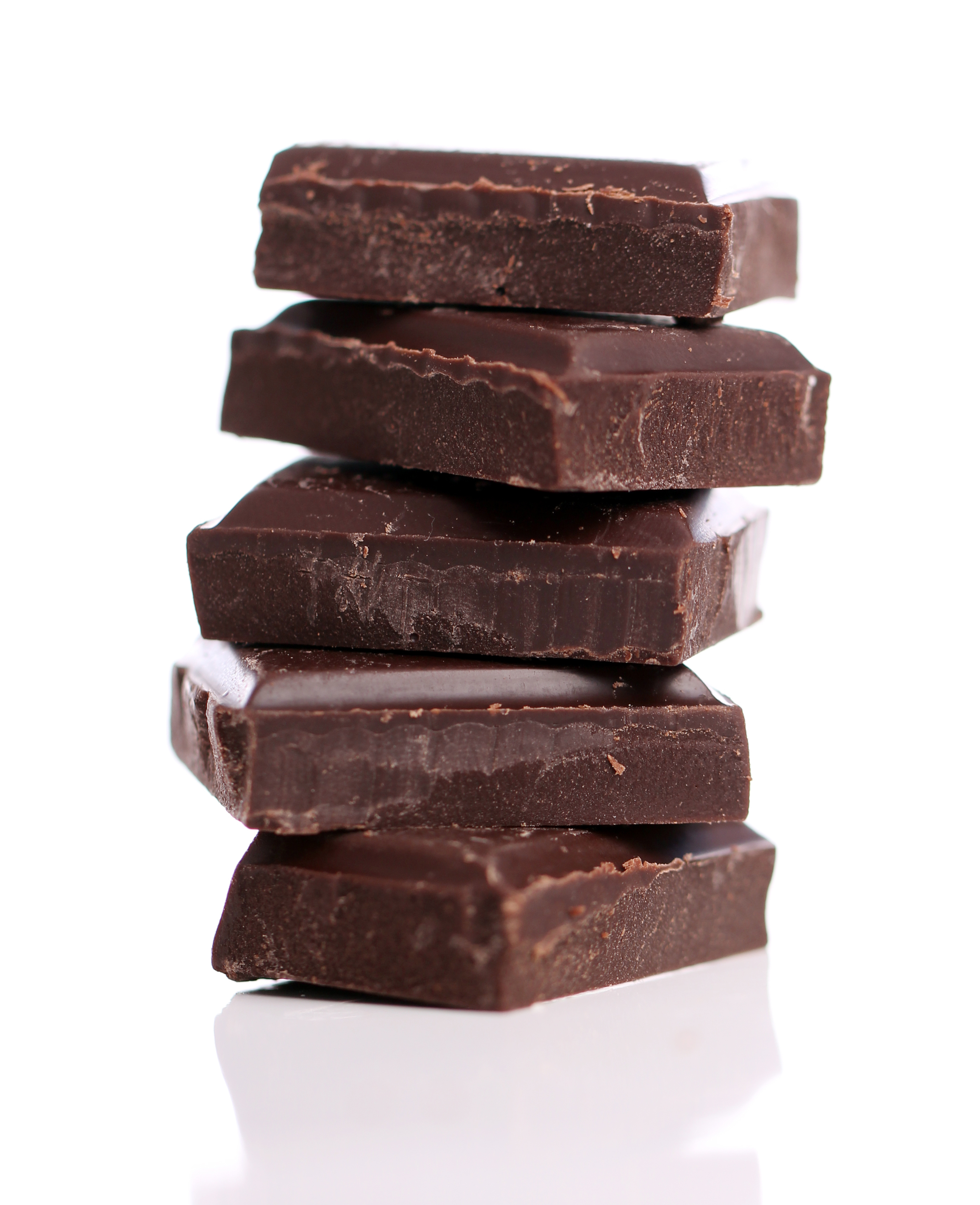 Pieces of black chocolate against white background